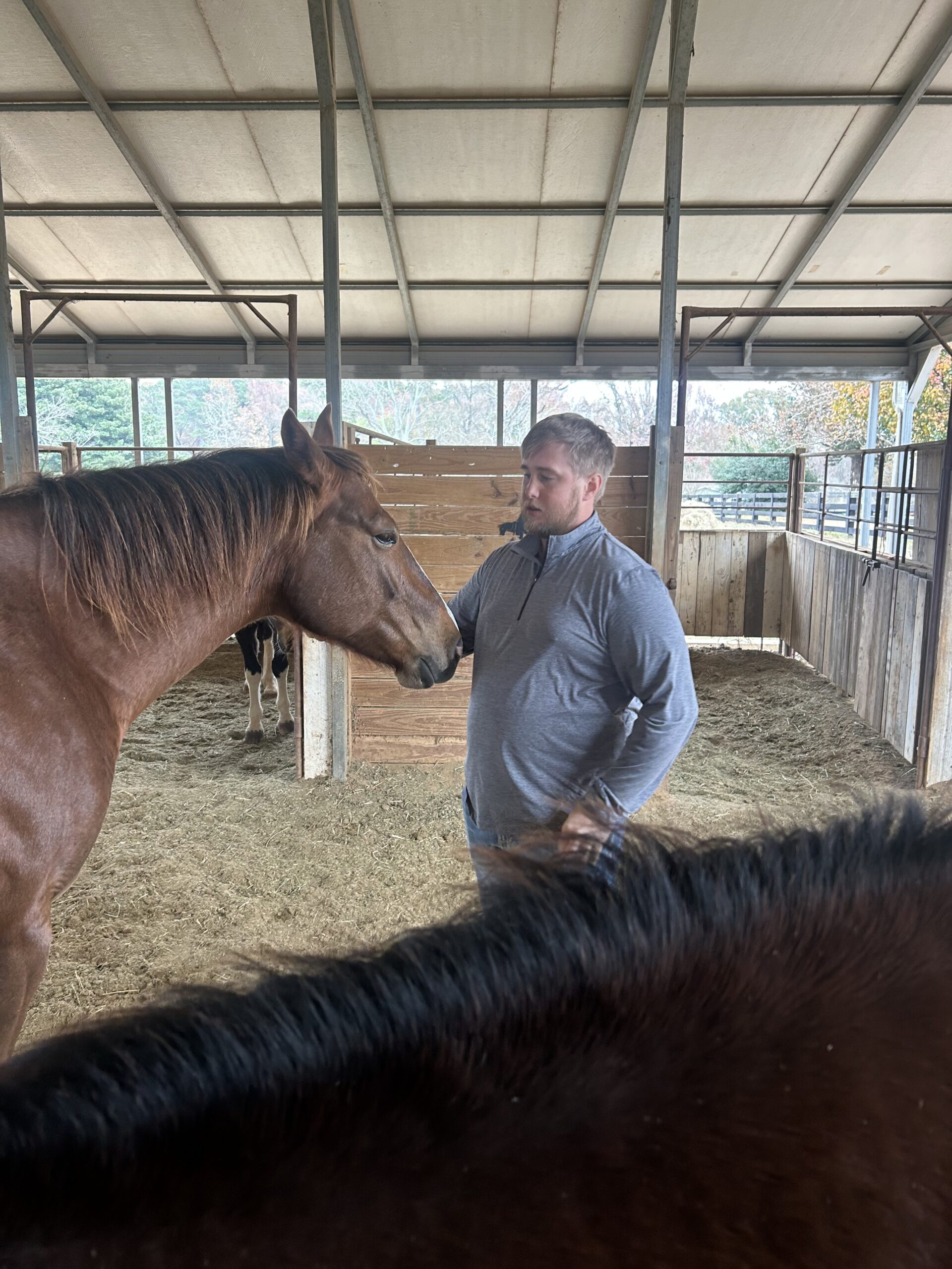 Mitchell with a horse in the barn at Morning Glory Ranch